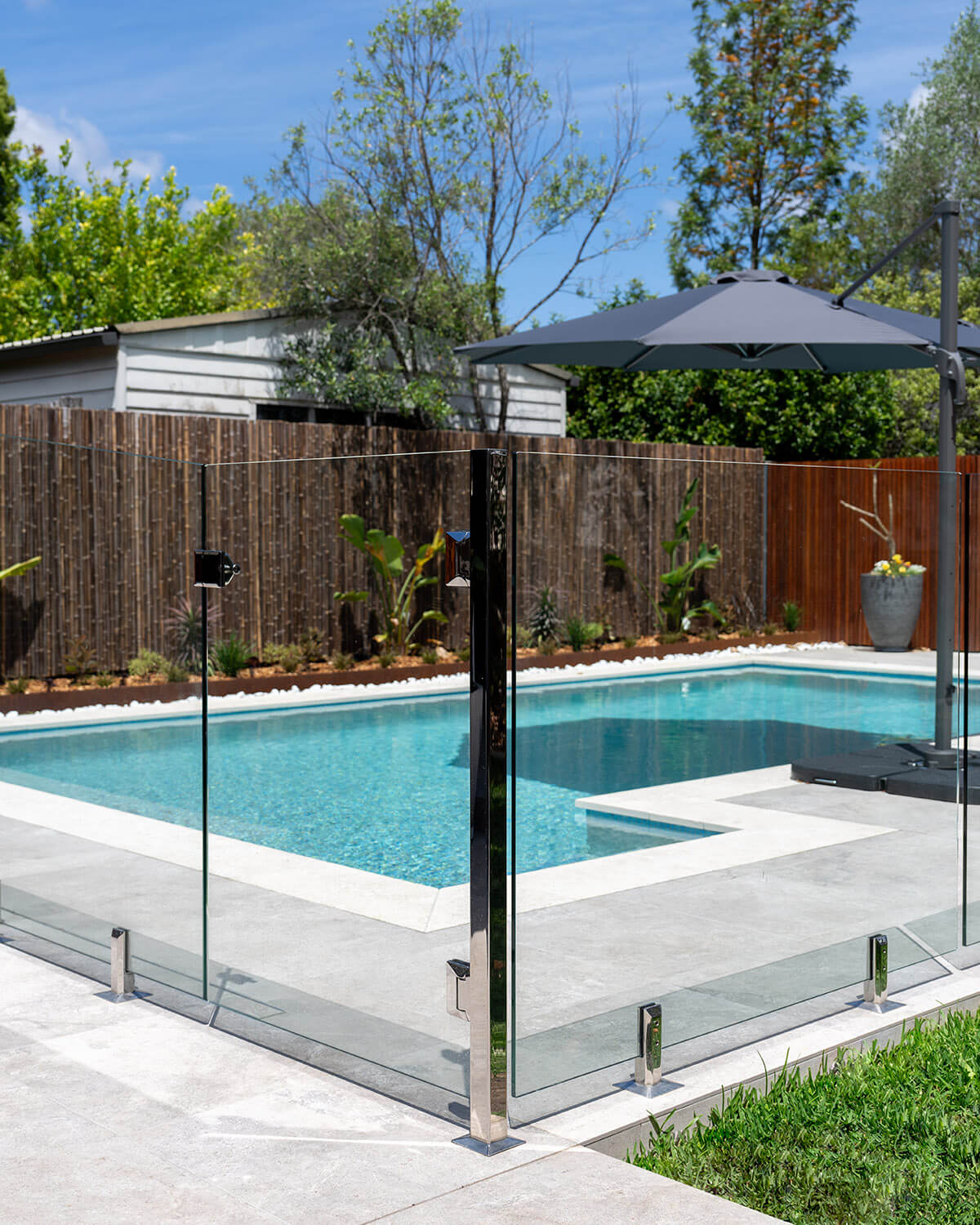 Frameless pool glass fencing in residential backyard in Thornleigh, Sydney with stainless steel post & spigots.